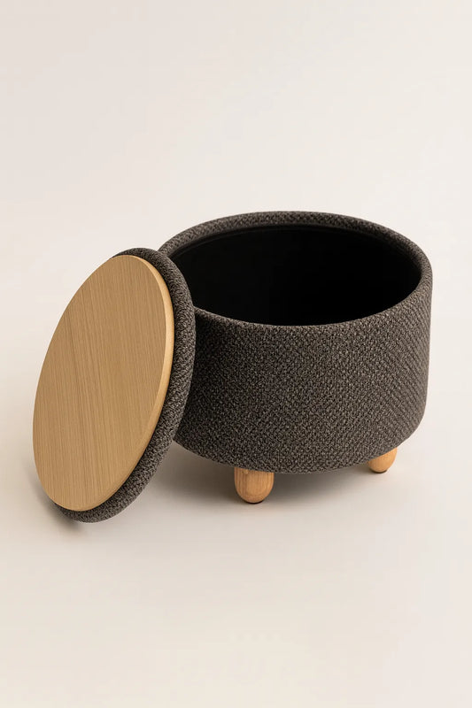 Textured black storage basket with wooden lid and legs on a light background