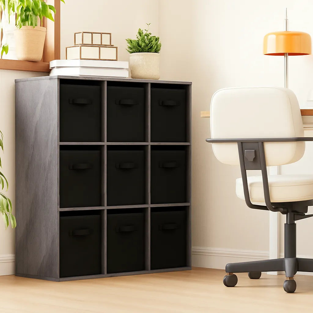 Black cube storage unit with drawers in a room with a chair and plants.