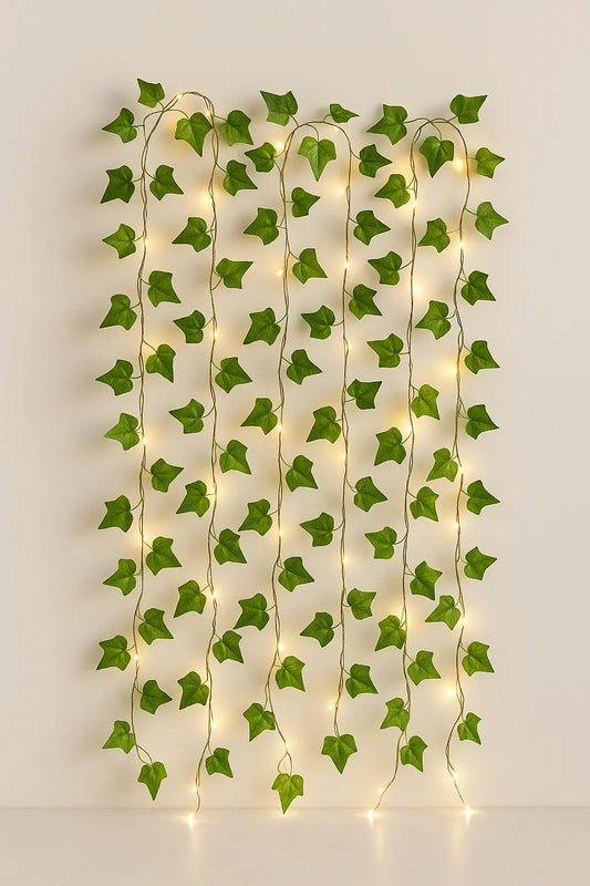 Decorative string lights shaped like ivy leaves on a plain wall.