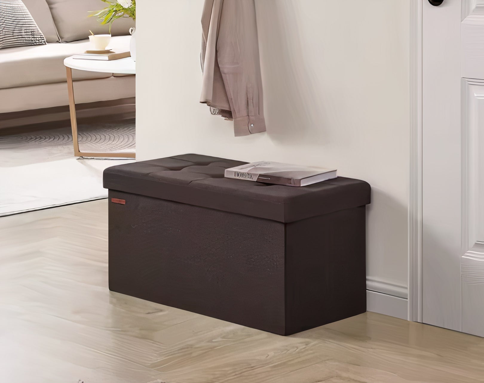 Brown storage ottoman in a living room setting with a couch and coffee table in the background.