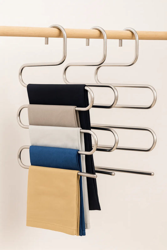Metallic multi-layer hanger with folded clothes on a plain background