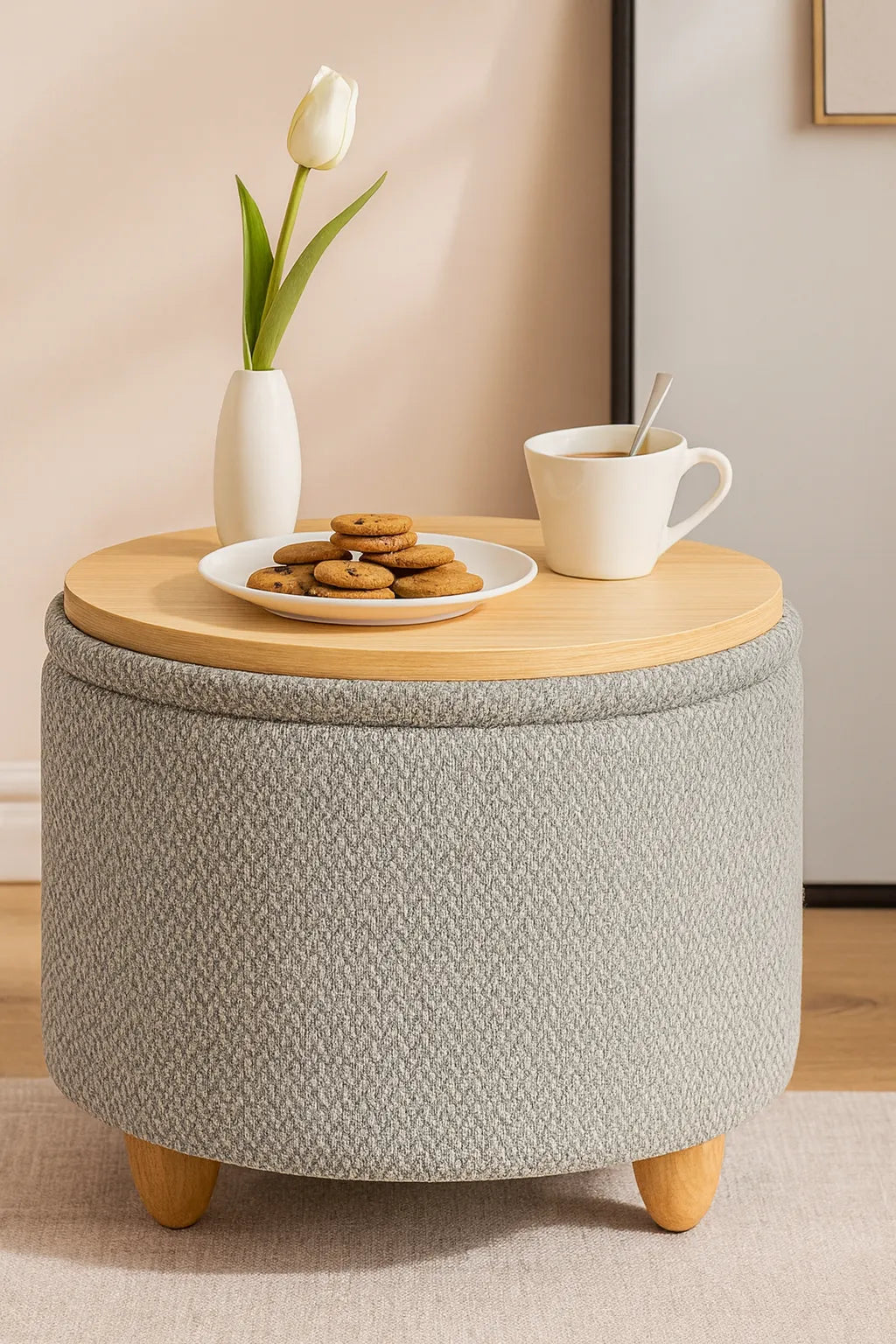 Round storage ottoman with a wooden top, cookies, a mug, and a tulip in a vase on a beige carpet.