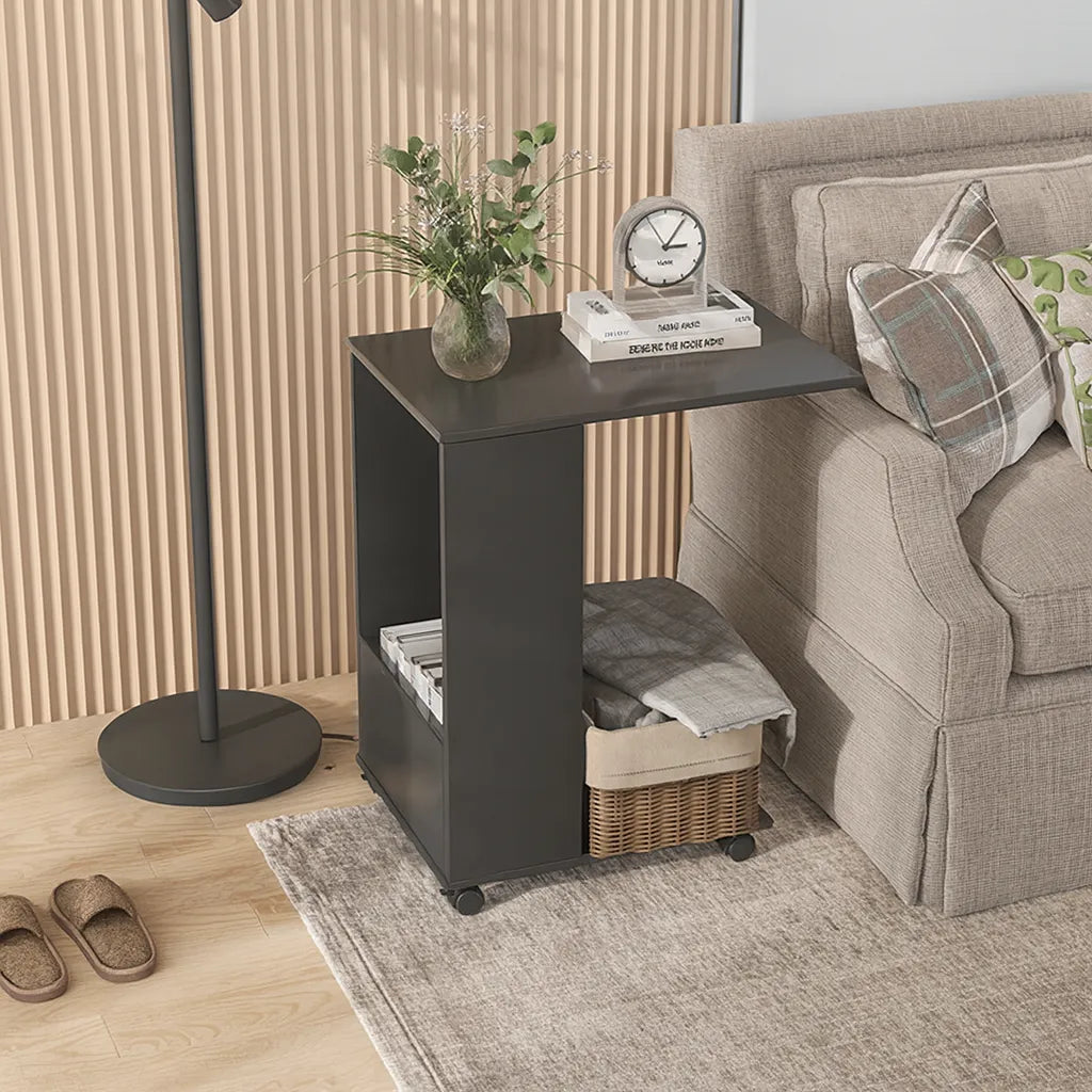 Black side table with decorative items next to a beige sofa in a living room setting.