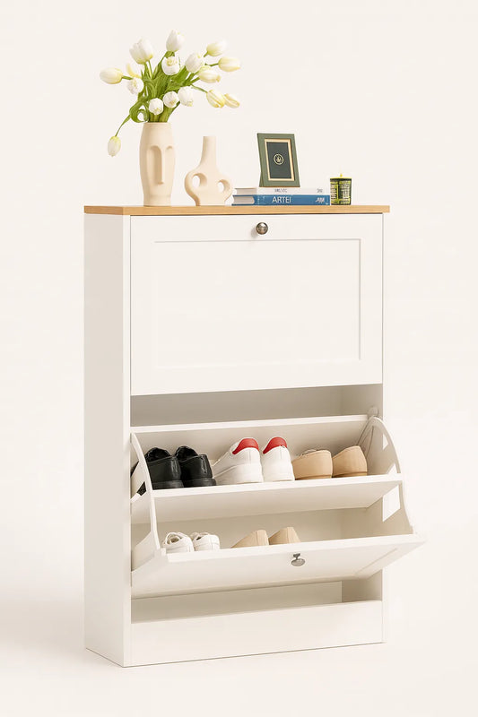 White shoe cabinet with open door displaying shoes, topped with decorative items on a white background